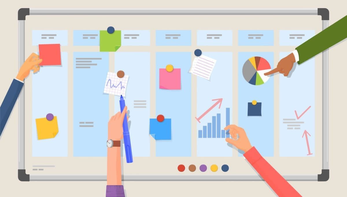 Hands interacting with a colorful project management board filled with sticky notes, charts, and graphs, symbolizing the benefits of project management.
