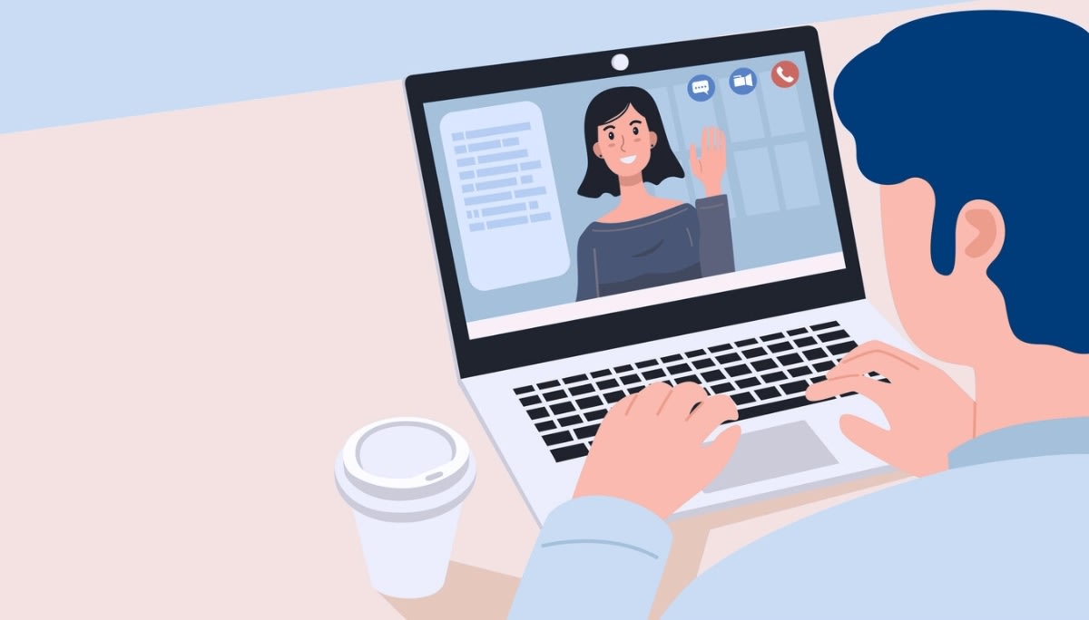 Person on a laptop having a one‑on‑one video call, with a woman waving on screen.