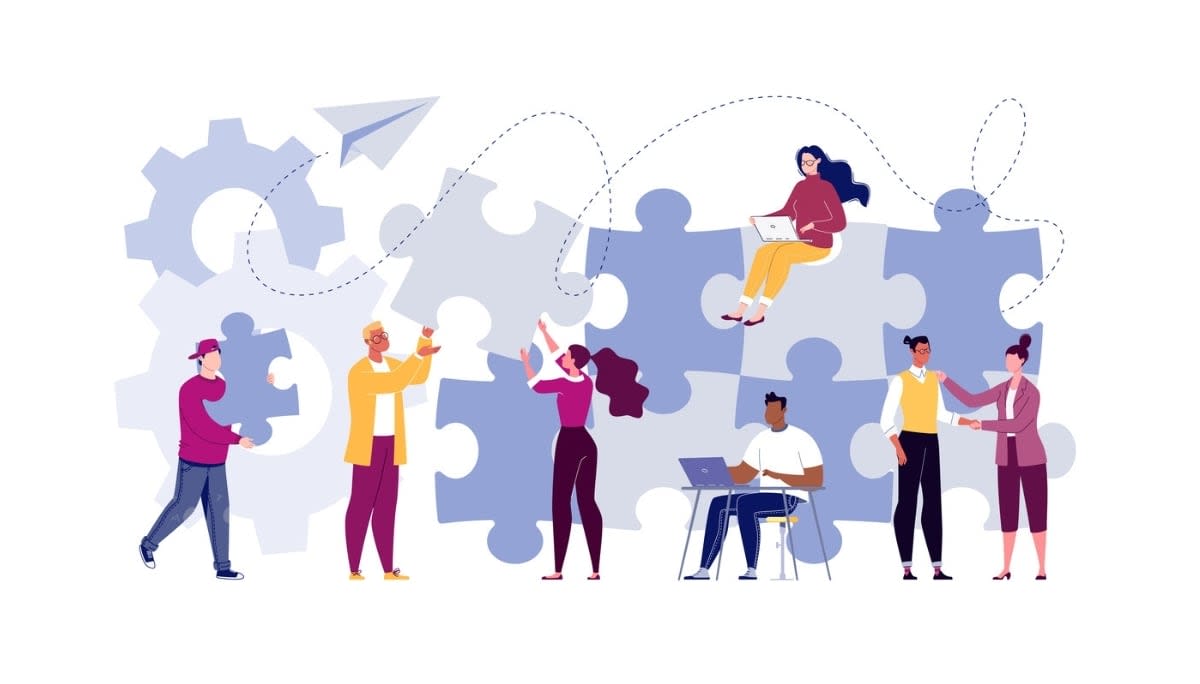 Illustration of six people collaborating with oversized puzzle pieces and gears—some placing pieces, others working on laptops or shaking hands.