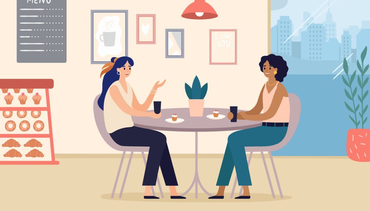 Two people talking at café table with drinks and desserts, symbolizing building rapport and workplace relationships.