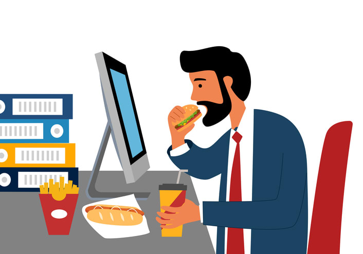 Businessman eating while working in front of computer