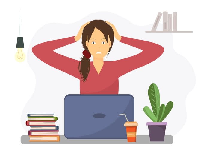 Stressed young woman at workplace holding her head